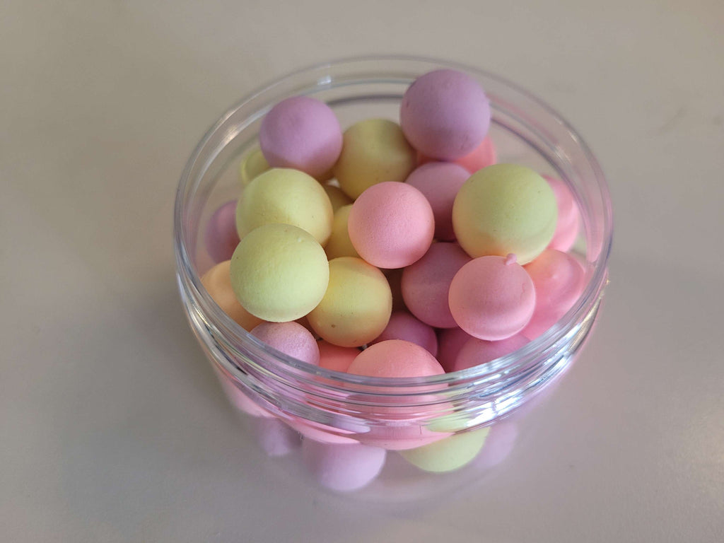 Clear jar filled with pastel-colored round hook baits on a light background