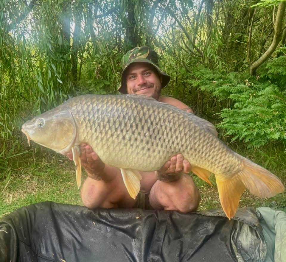Man holding a large fish in a natural outdoor setting