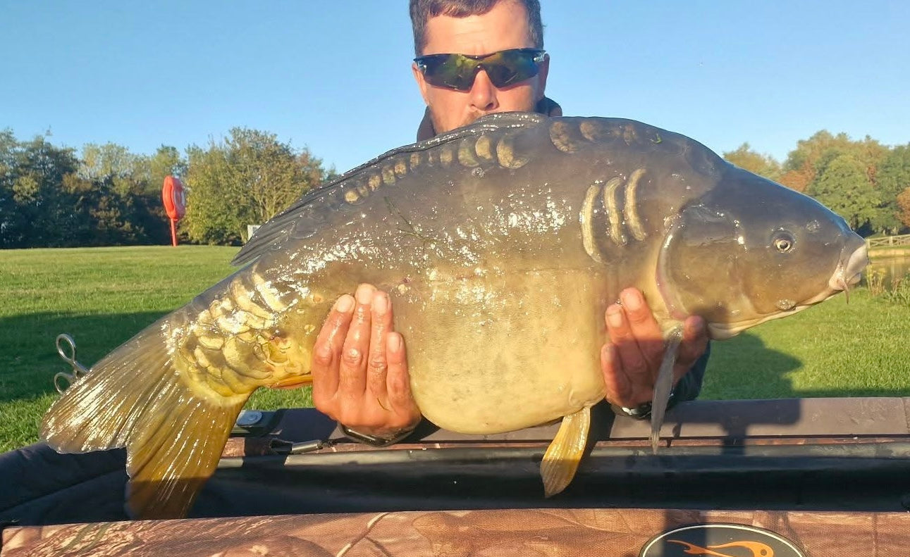 Carp angler with a mirror carp