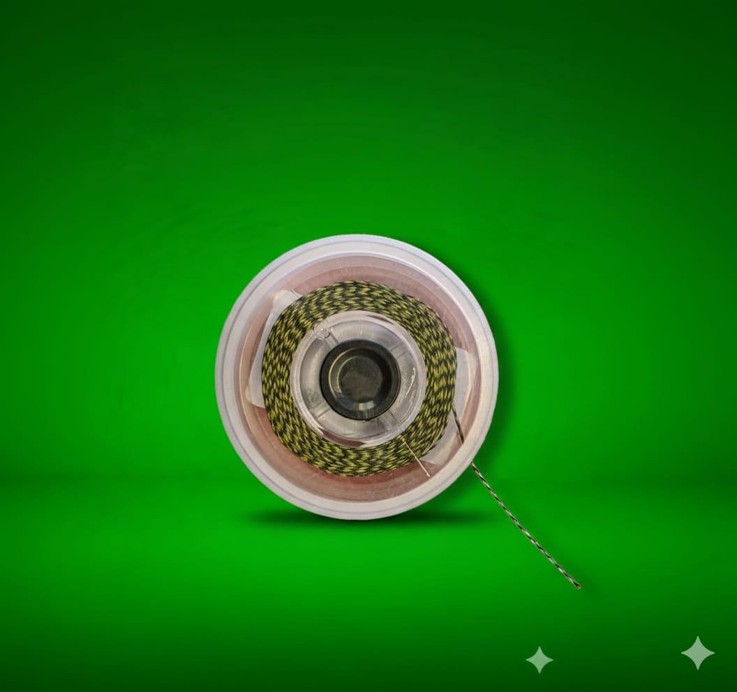 Spool of green Snare Supple Braided Hook Link on a white plastic reel against a green background
